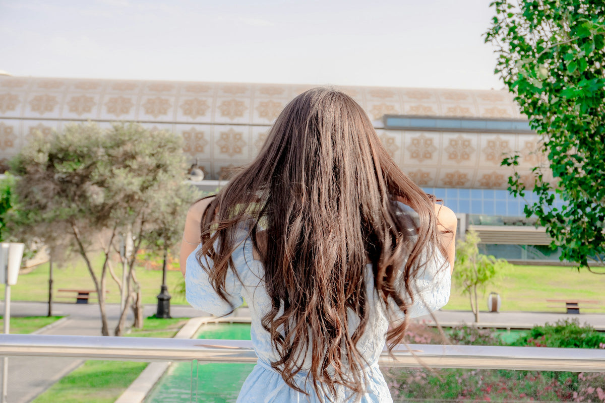 Frau mit langen, glänzenden braunen Haaren von hinten – Herbst-Brünett