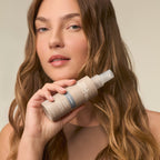 Model hält das Paul Mitchell 15-in-1 Spray in der Hand