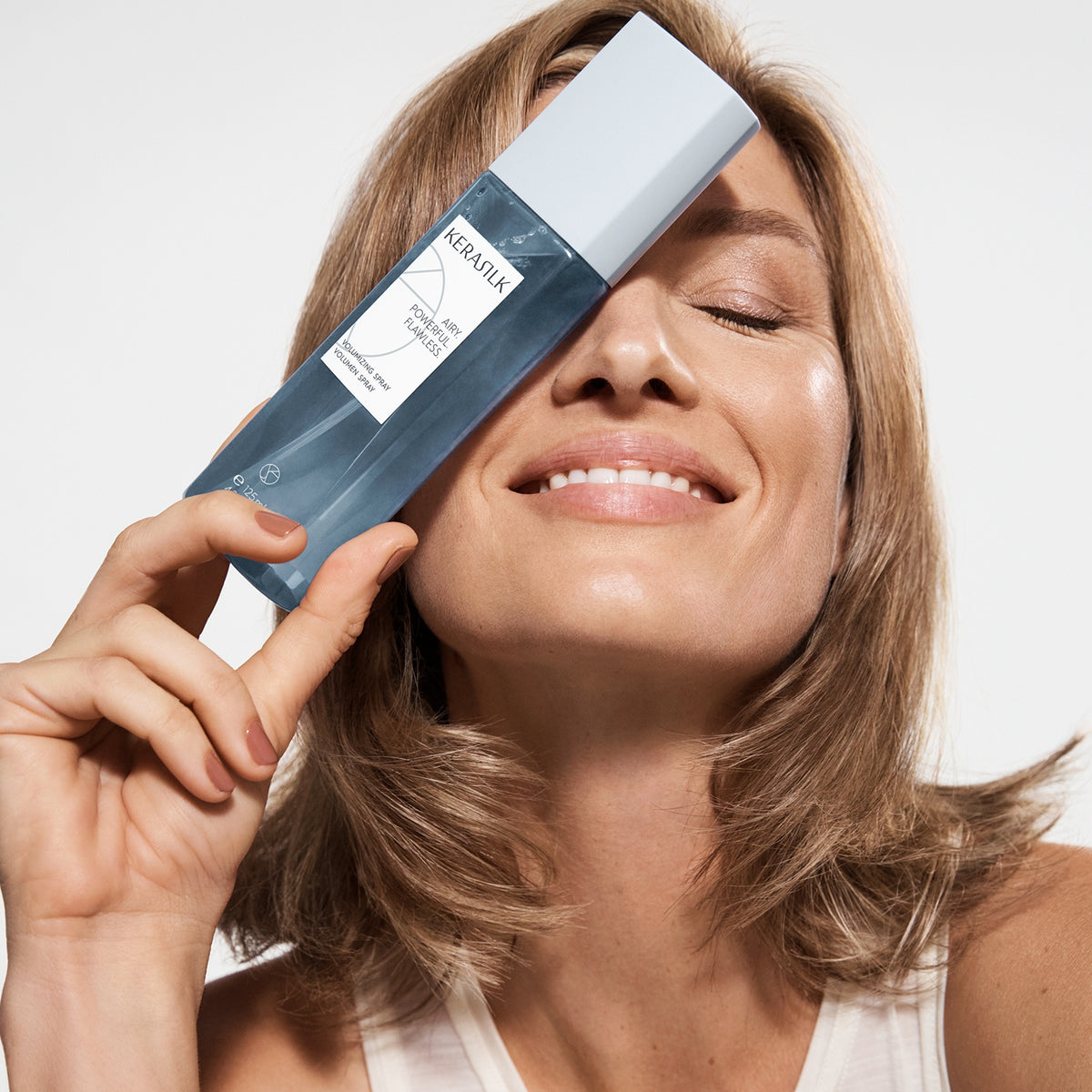 Kerasilk Volumen Spray, Model hält Sprühflasche an den Ansatz