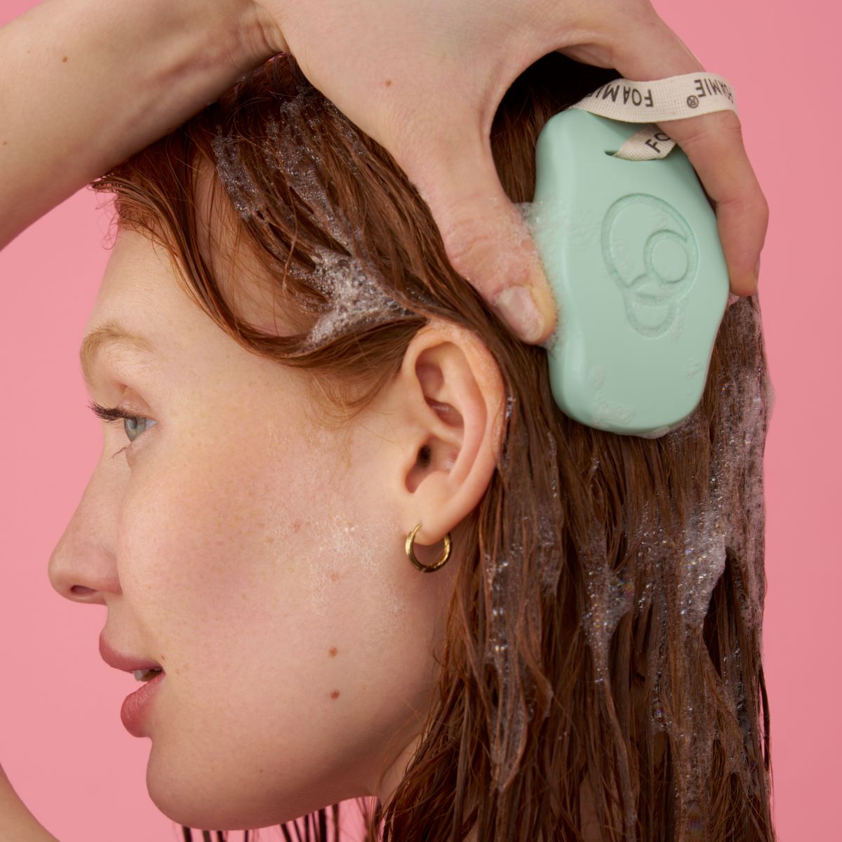 Foamie Festes Shampoo Scalp – Anwendung: Frau hält das feste Shampoo an den Ansatz