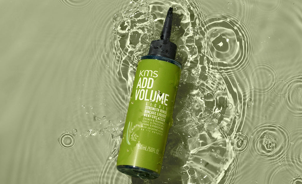 KMS Addvolume Liquid Strength Flasche liegend in Wasser auf grünem Grund