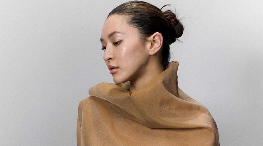 Model mit glattem, streng gestecktem Dutt – starker Halt mit Paul Mitchell Firm Hold