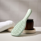 Tangle Teezer Extra Gentle Bürste neben Handtuch und Pflegetiegel