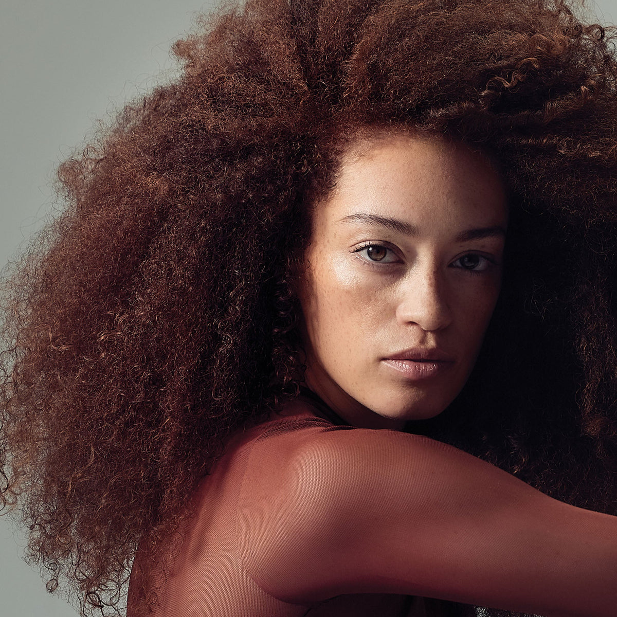 Farbschutz & coloriertes Haar – Model mit kupferrotem Lockenhaar