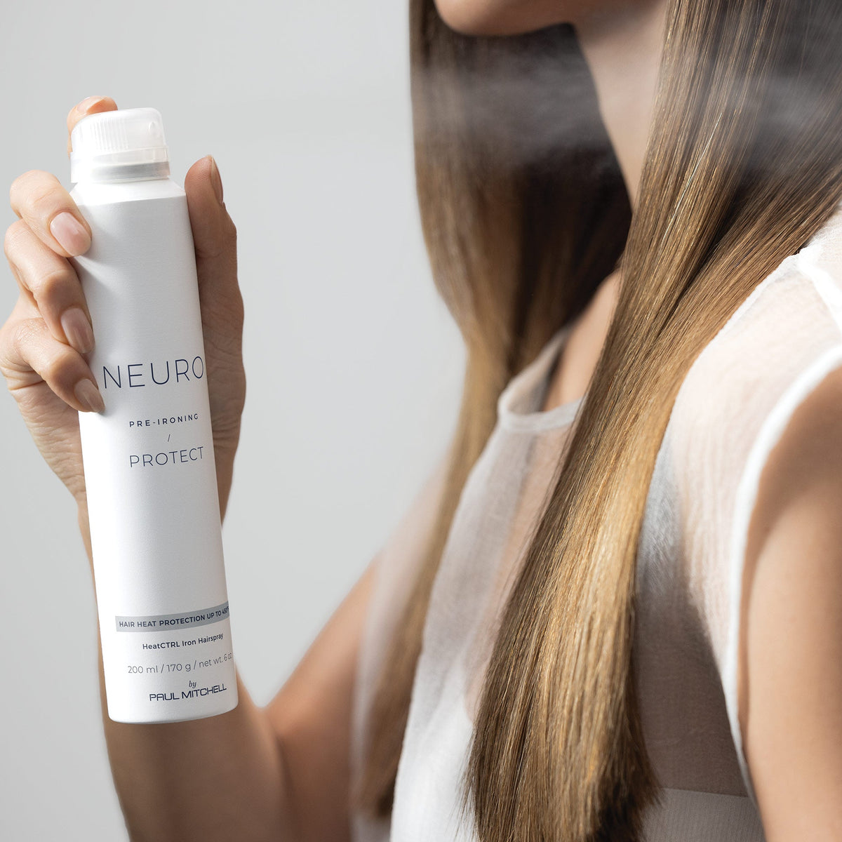 Hitzeschutz – Model sprüht Hitzeschutzspray ins Haar