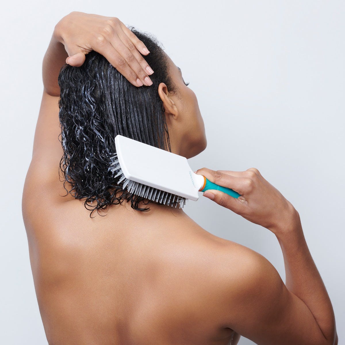 Moroccanoil – Model beim Einarbeiten der Haarpflege ins nasse Haar